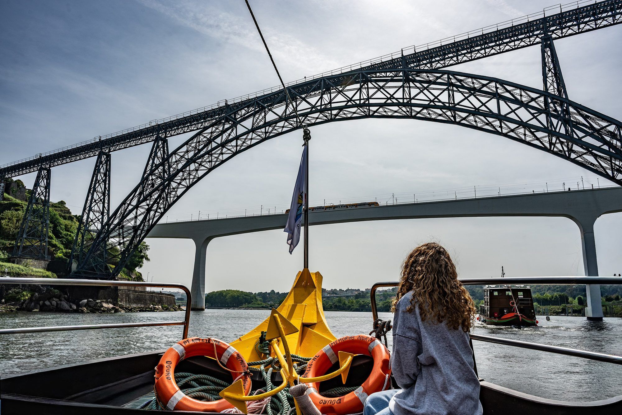 Ticket kiosks and moored rabelo boats along Cais da Ribeira in Porto