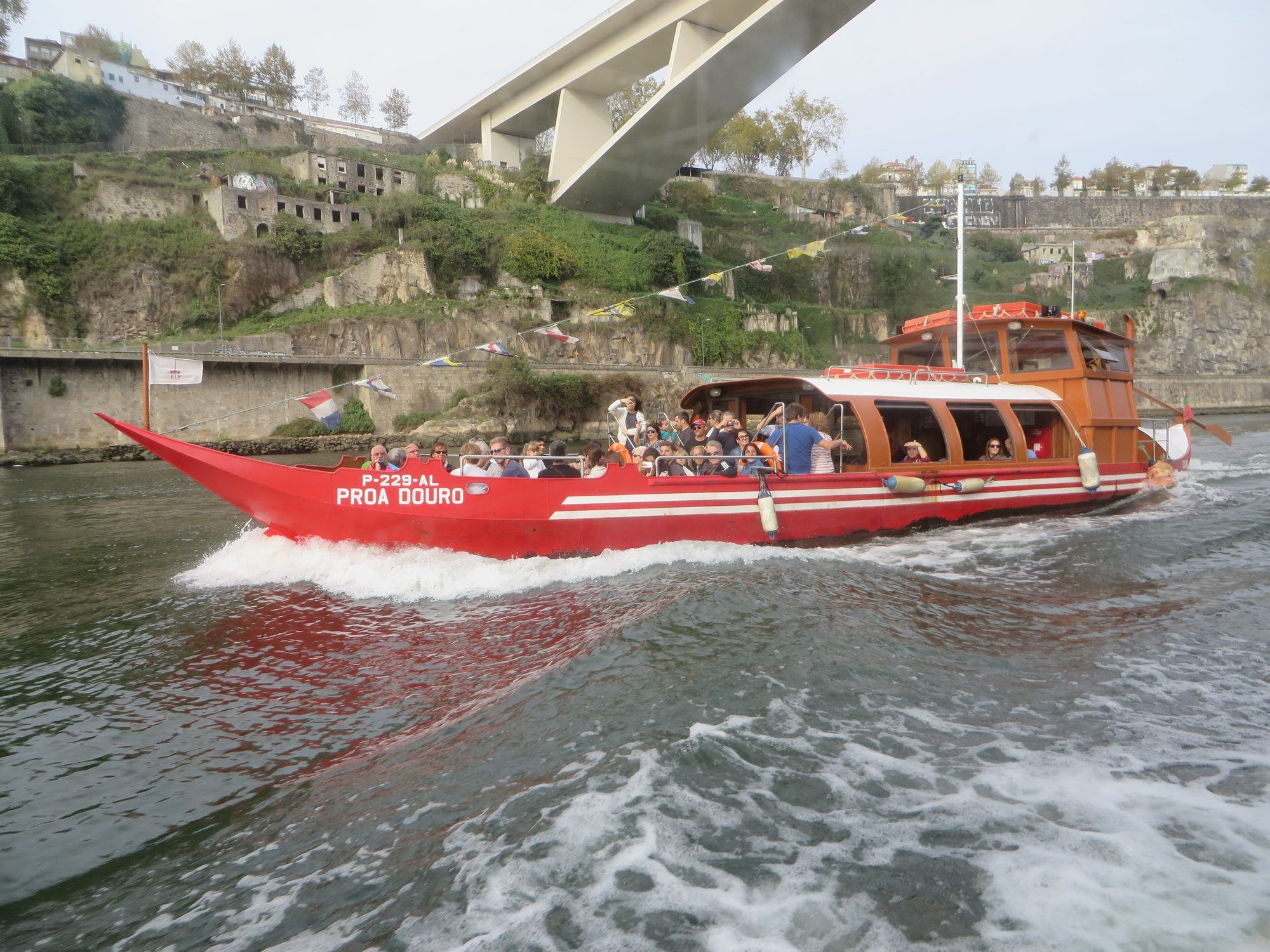 Tourist boats moored below the Dom Luís I Bridge at Cais da Ribeira in Porto